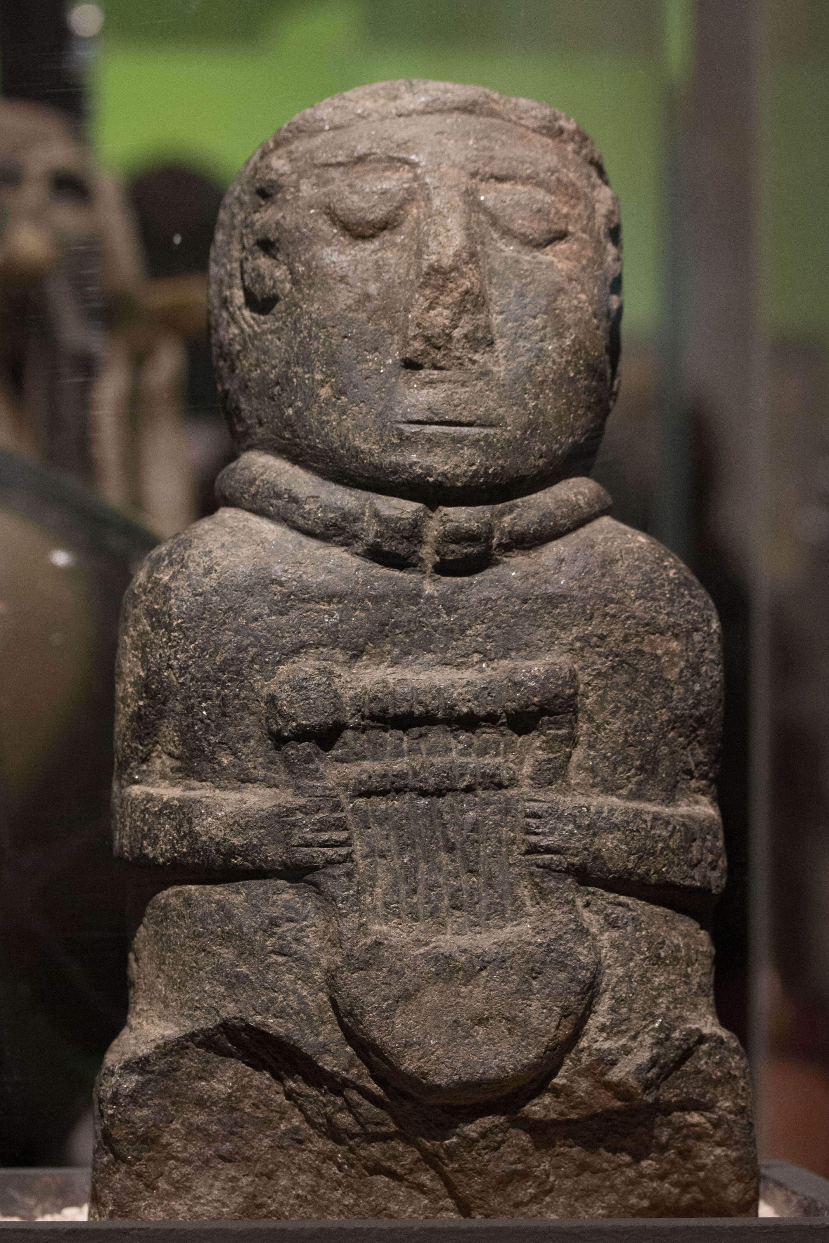 Image of a stone-cut human figure with a lyre